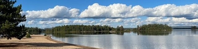 Photo of a sunny beach with white fluffy clouds